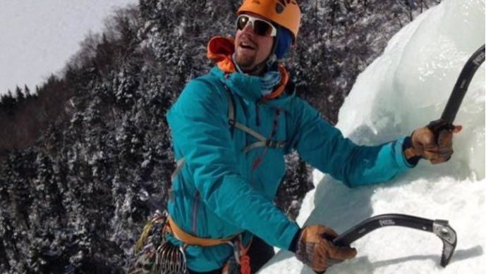 an ice climber looking up at the rest of his route