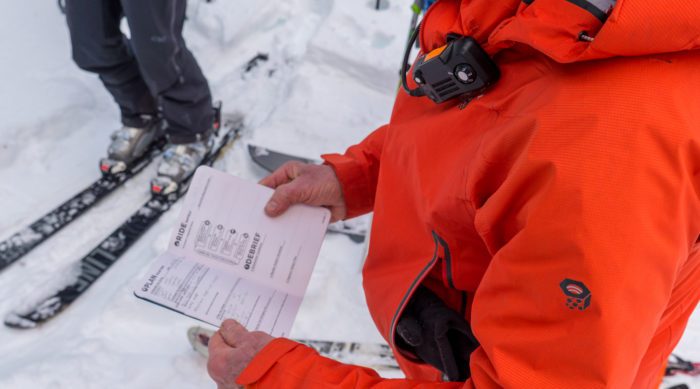 A mountain guide recording snow observations.