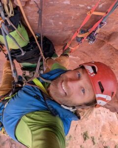 Male rock climber taking a selfie while big wall rock climbing in the desert.