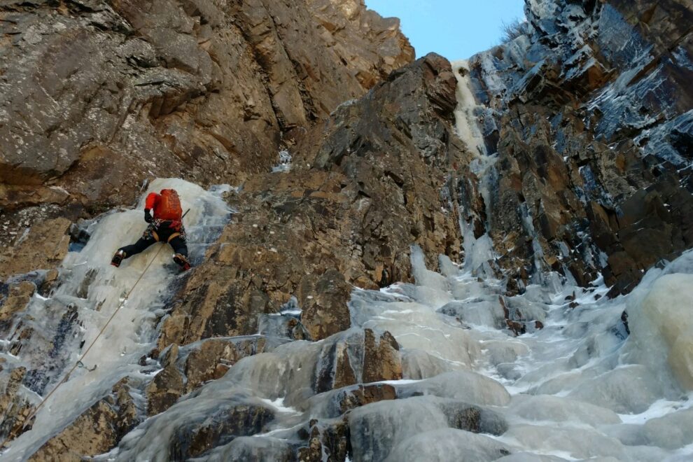 Lead climber ice climbing in mixed conditions.