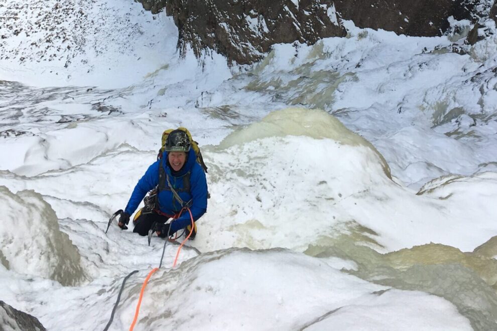 Male ice climbing on top rope.