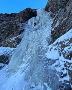 a climber near the summit of a frozen waterfall
