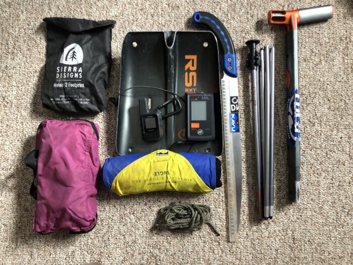 An avalanche shovel, probe, beacon, snow saw, snow sled, and additional emergency items