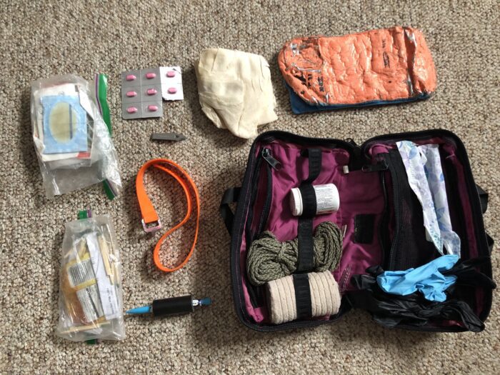 A backcountry ski first aid kit including paracord, triangle bandages, tampons, sam splint (can be used to splint a broke pole as well), medications/pain killers, ace wrap, latex gloves, matches, lighter, alcohol wipes, antiseptic ointment, and bandaids