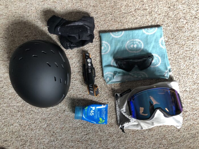 Googles, sunscreen, a ski mountaineering helmet, sunglasses, socks, a headlamp, and buff. 