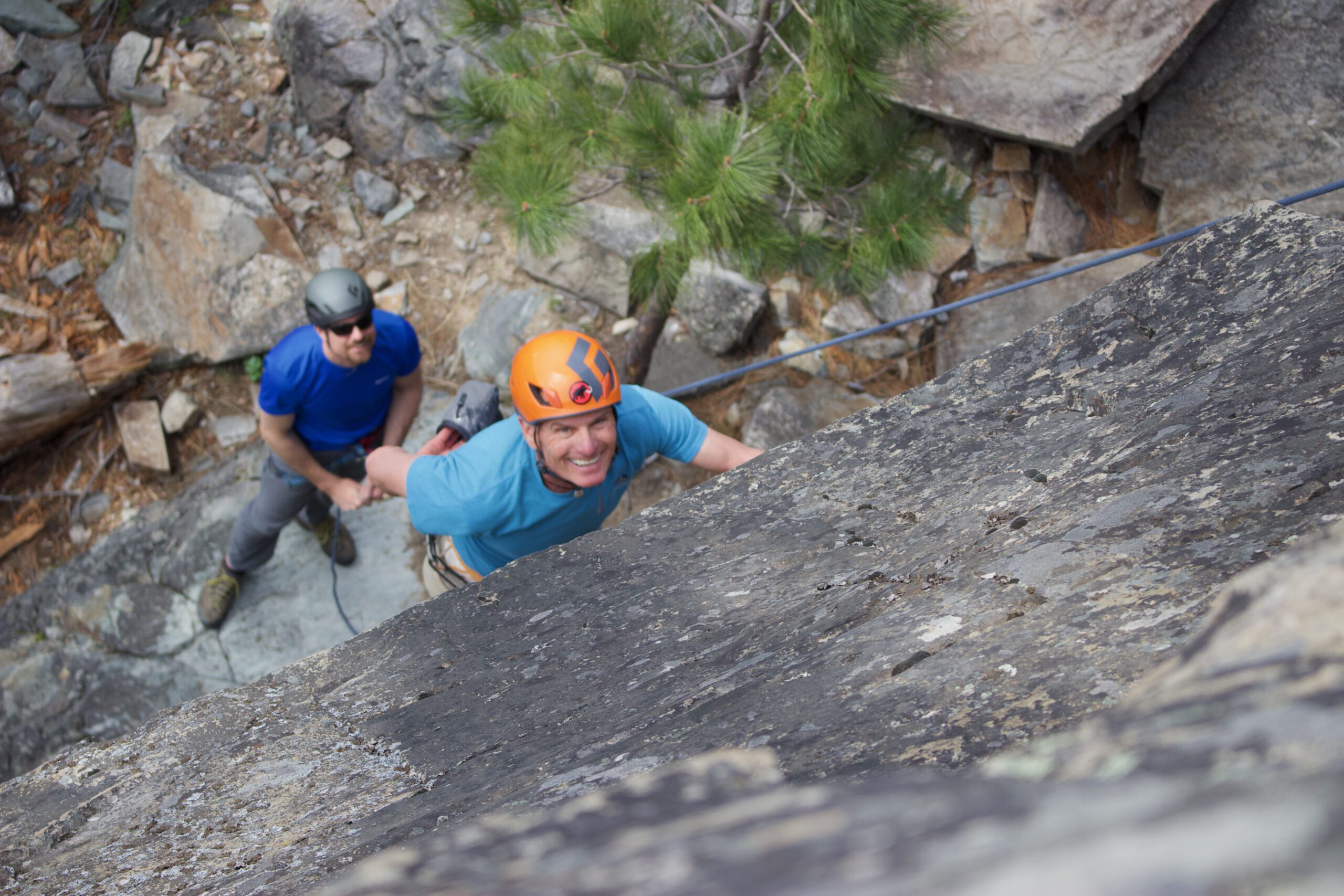 A man in an orange helmet sport climbs outside Glacier National Park. 